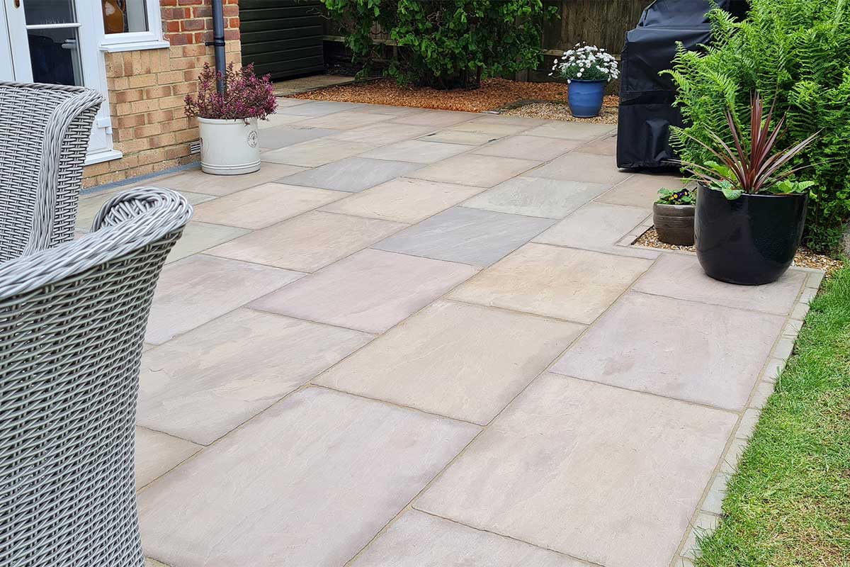 Raj Green Indian sandstone patio paved with 900x600mm slabs and matching slim edging stones from Love Stone