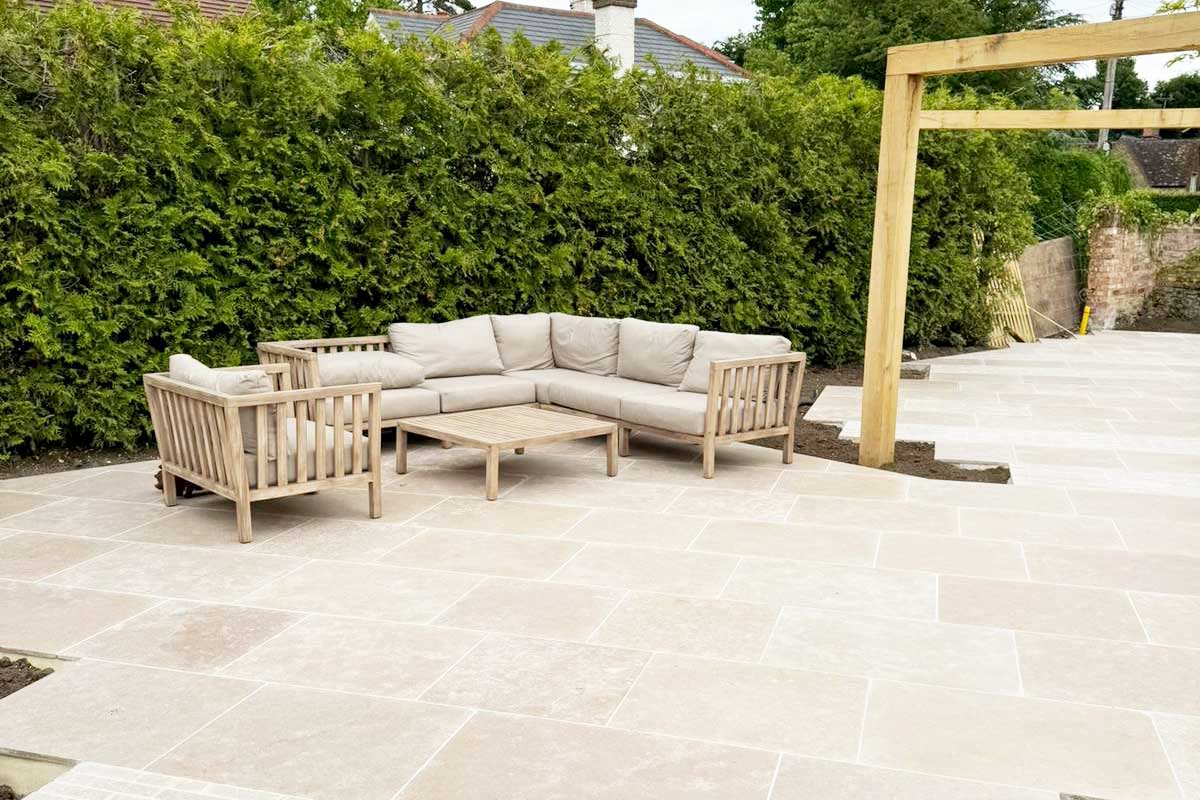Large Sanai Pearl light toned limestone paved patio and seating area