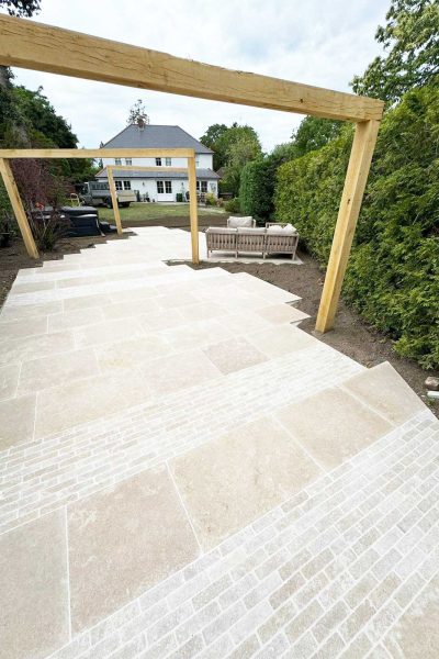 Large path and patio in Surrey featuring Sanai Pearl limestone paving and setts